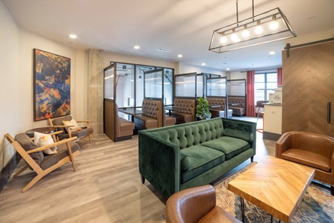 a living room with a green couch and chairs